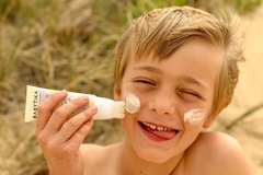 Image child putting suncream on