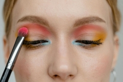 Image A woman applying colorful eyeshadow.