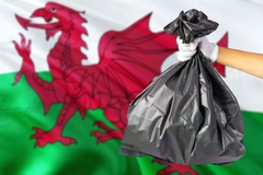 garbage bag in front of Welsh flag, red dragon