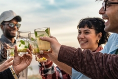 a group of friends cheering with healthy drinks in their hands in glasses