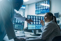 Image Neuroscientists examine brain imaging scans in an office.