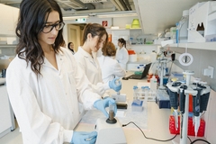 young female scientist working in the lab with a brown liquid