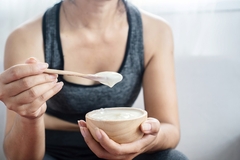 Image A woman eating yogurt.
