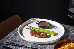 Image cultivated foie gras on a white dish against a black background