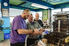 Image men standing around a machine