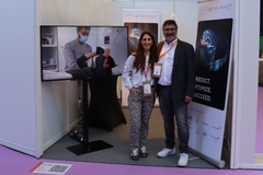 People standing outside of a booth at a trade show.