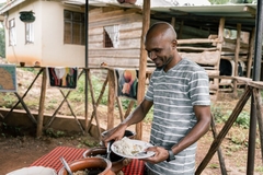 Image Man serving traditional food in Tanzania