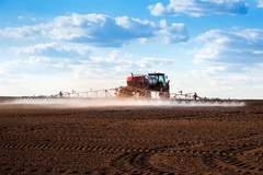 A tractor spraying pesticide in the field.