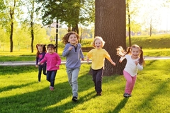 Happy children running and playing in a park.
