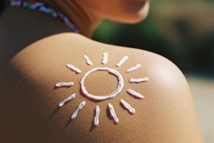 Woman with sunscreen shaped as the sun at the beach