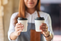 Image barista holding two to-go paper cups