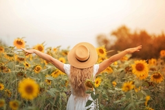 Image A woman standing in a field of sunflowers.