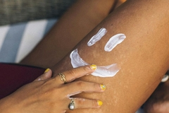 Image woman applying cream to leg in smiley face