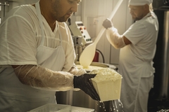 Image man in a factory making cheese
