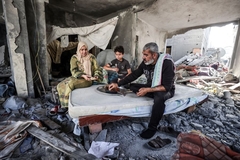 Image A family in Palestine eating foof in the rubble.