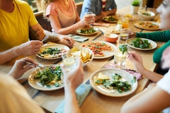 Image People eating plant-based food around a table.