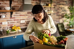 Image Woman in kitchen checking produce box