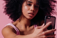 Image woman holding phone up to face
