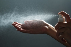 Image Hand sanitizer spray being sprayed on a hand.