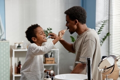 Image A father and son brushing each other's teeth.