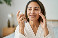 Image woman healthy aging putting moisturizer on face
