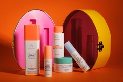 Image colorful drunk elephant skin care products against orange backdrop