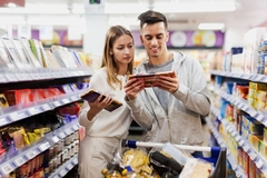 Image Customers in supermarket looking at chocolate packaging.