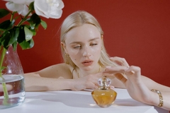 woman holding a bottle of fragrance