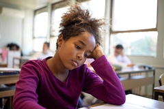 Image sad girl at school desk