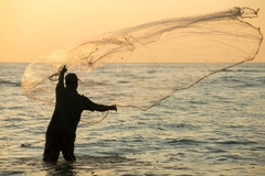 Image fisherman throwing net in the sea