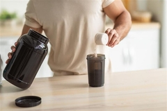 Image Man making protein shake in kitchen.