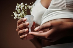 Image woman holding a period cup with flowers in it