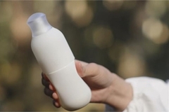 A hand holding Shiseido's squeeze bottle.
