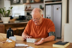Image Senior man checking blood pressure