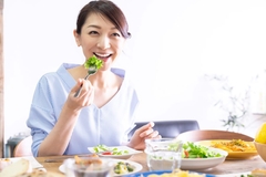 Image happy asian woman eats greens
