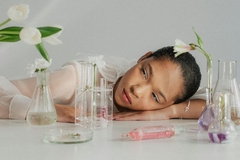 Image woman lying on table with science test tubes and flowers