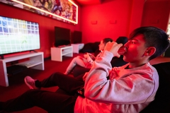 Image A young boy drinking cola while watching football.