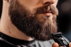 Image Man trimming beard with razor.
