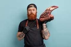 Image bearded man carries a chunk of meat on his shoulder
