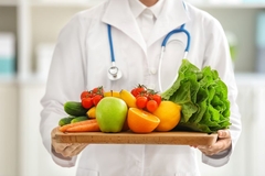 Nutritionist holding plat of fruits and vegetables