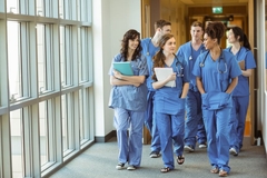 Image med students in uniform walk in corridor chatting