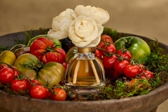 Image A fragrance surrounded by tomatoes.