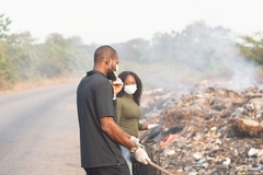 two people with masks on at a waste site