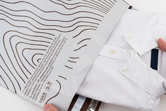 Image A person holding a white shirt from a bag