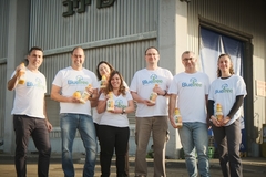 a group of people in white shirts holding juice bottles
