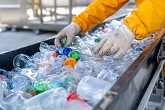 A person in gloves sorting plastic bottles