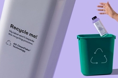 Image A person throwing a bottle into a recycle bin