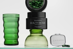 Image Sakara's Beauty Biome on green glasses on a clear glass table.