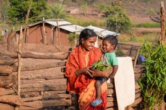 woman carried son on her hip in village