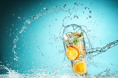 Image splash of lemon cocktail against a blue background
